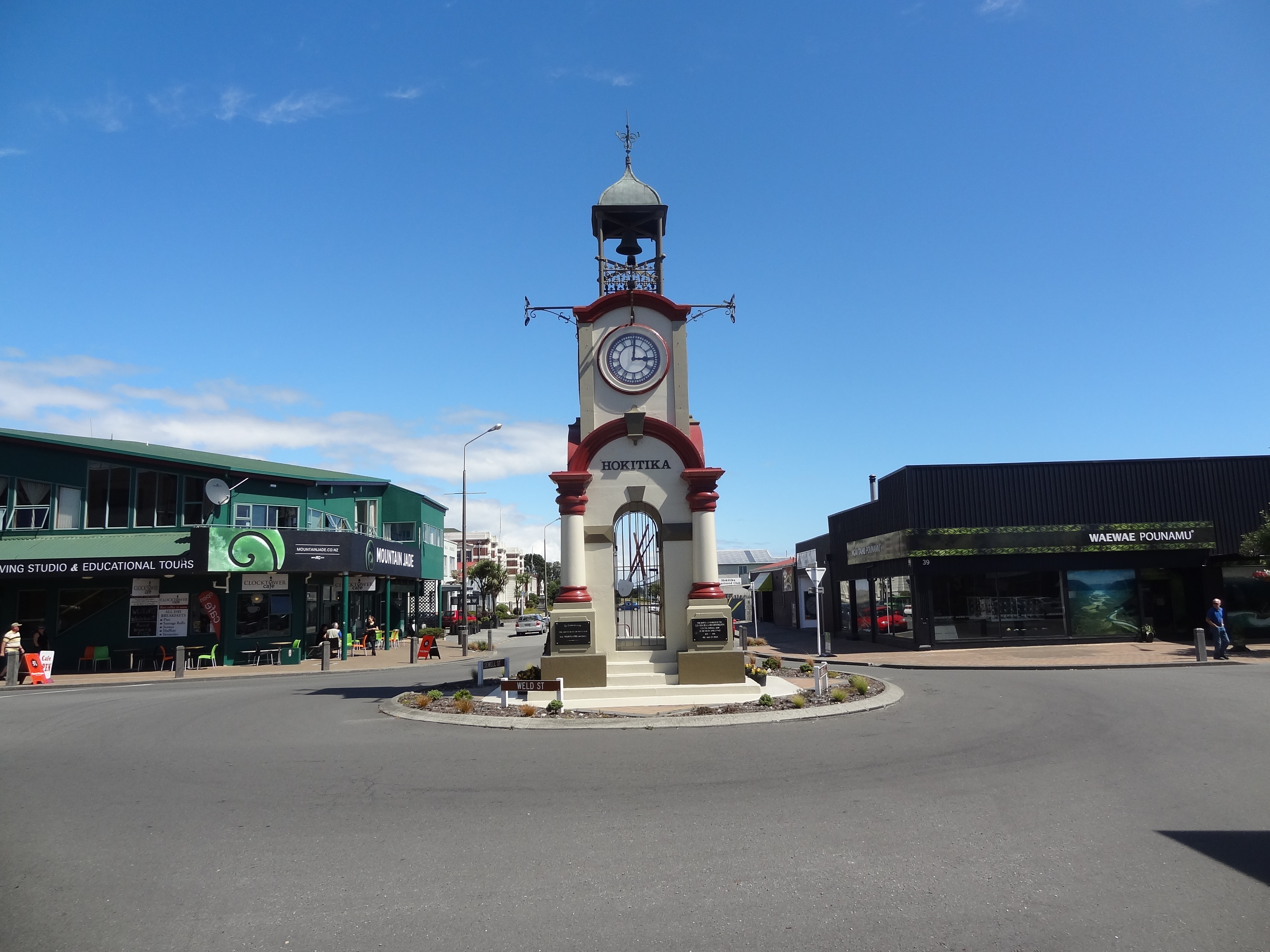 Hokitika Clock Tower.The first shops that can be seen on either side of the road are Pounami ( Greenstone ) Centres 